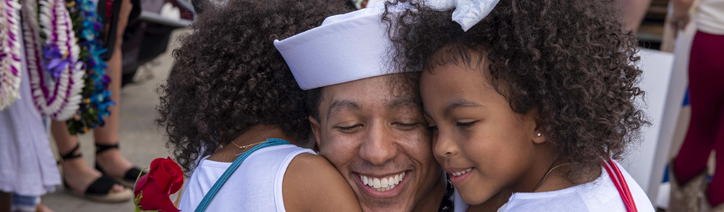 Sailor hugging his daughters