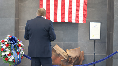 Man standing in front of wreckage recovered from 9/11